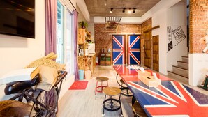 A modern interior with a long dining table, a bicycle, and a Union Jack-themed floor. - Anping 156 B&B (Tainan)