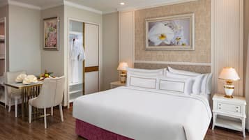 Une chambre d’hôtel avec un grand lit, des tables de chevet, un bureau avec une chaise et un tableau au mur.