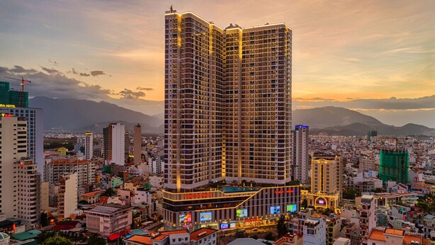 Un hotel de gran altura con varios pisos, una piscina en la azotea y señalización llamativa.