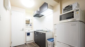 Una cocina compacta equipada con microondas, fregadero, lavavajillas y cubo de basura.