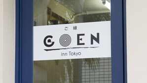 Una puerta azul con un letrero que dice "COEN inn Tokyo" y una cerradura con teclado.