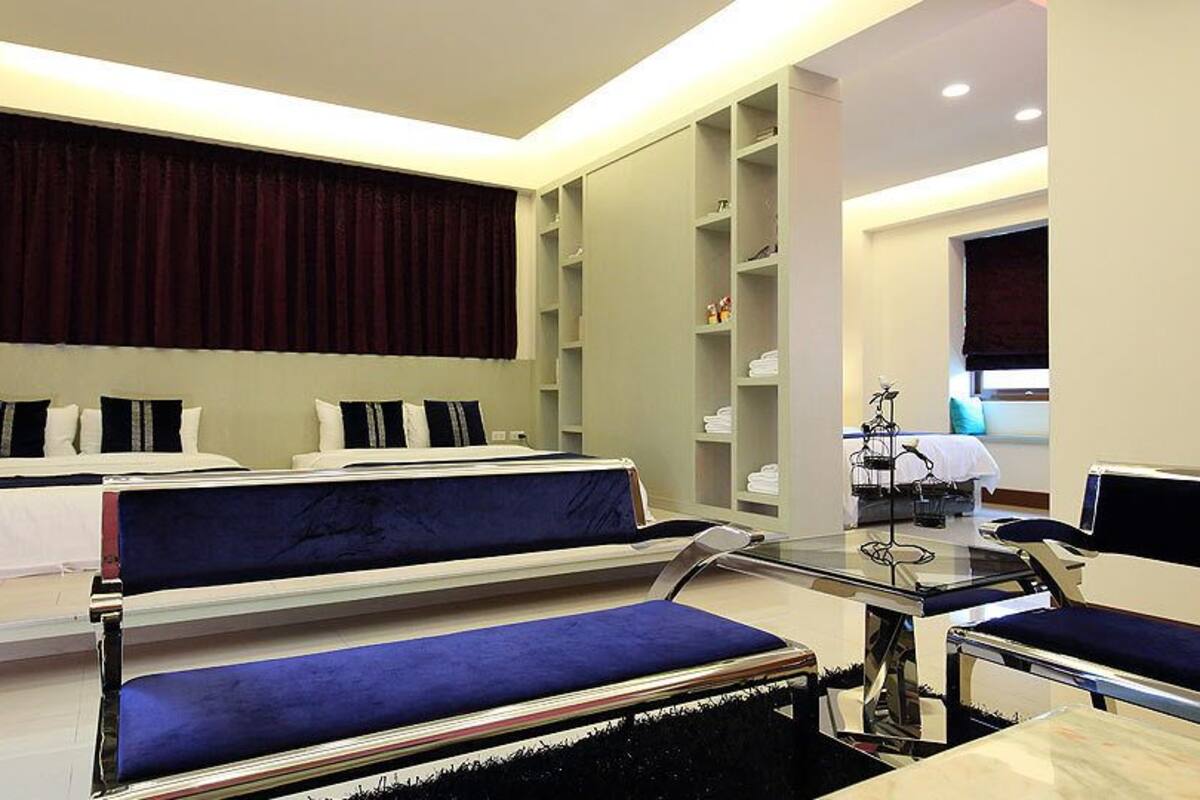 Una habitación de hotel moderna con dos camas, un escritorio y un vestidor.