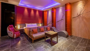 Um spa moderno com uma cadeira de massagem, um sofá e uma mesa pequena.