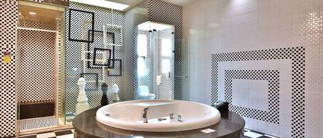 A modern bathroom with a freestanding bathtub, checkered floor tiles, and patterned walls.