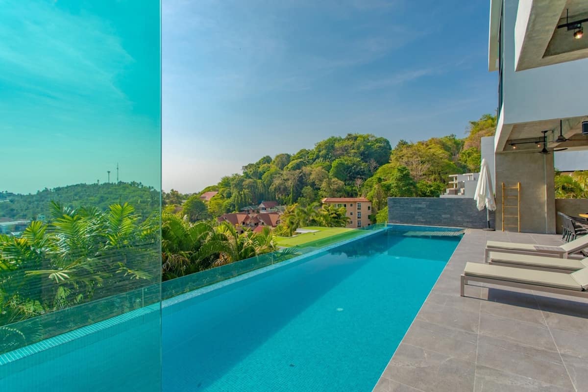 Una piscina moderna con vistas despejadas a un paisaje verde exuberante y una colina distante.