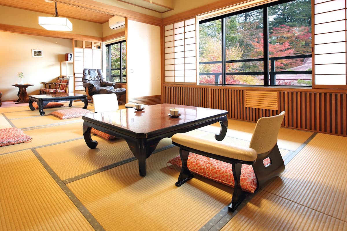 Une pièce de style japonais traditionnel, avec un sol recouvert de tatamis, une table basse et un banc rembourré.