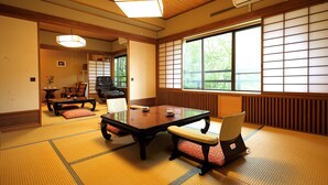 Een traditionele Japanse kamer met tatami vloerbedekking, een lage tafel en een schuifdeur.