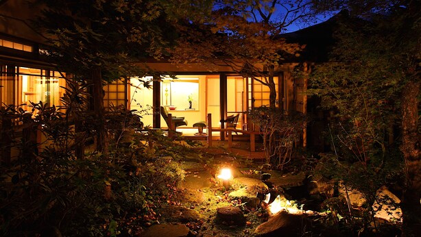 Een traditioneel Japans huis met een tuin in de schemering.