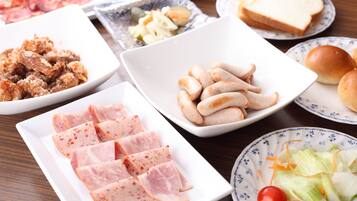A table with various food items including sliced meat, bread, and vegetables.