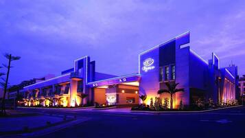 A modern hotel with a prominent entrance, a well-lit facade, and a clear sign indicating the name.