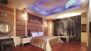 A bedroom with a bed, a desk, a chair, and a ceiling projection of space.