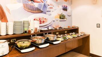 A buffet setup with various dishes and a large poster in the background.