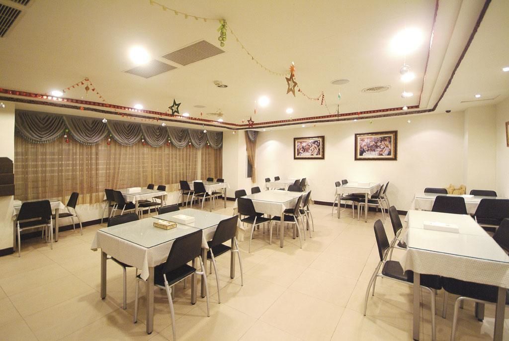 A conference room with multiple tables and chairs, arranged in rows.