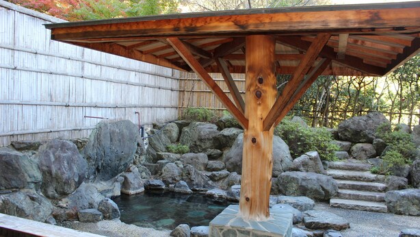 A wooden gazebo structure with a stone base, surrounded by a rock garden and a small pond. - Matsuriya Yuzaemon (Fukushima)