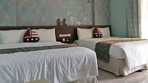 A hotel room with two beds, each with a sailboat pillow. The room has a patterned wallpaper and a window with curtains. - Aegean Sea Baoli (Taitung)