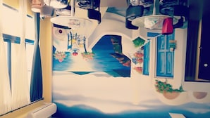 A room with a mural of a sea scene, a bed with a white frame, and a window with blue shutters. - Aegean Sea Baoli (Taitung)