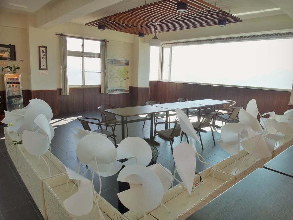 A conference room with a long table, chairs, and a wooden slatted ceiling.