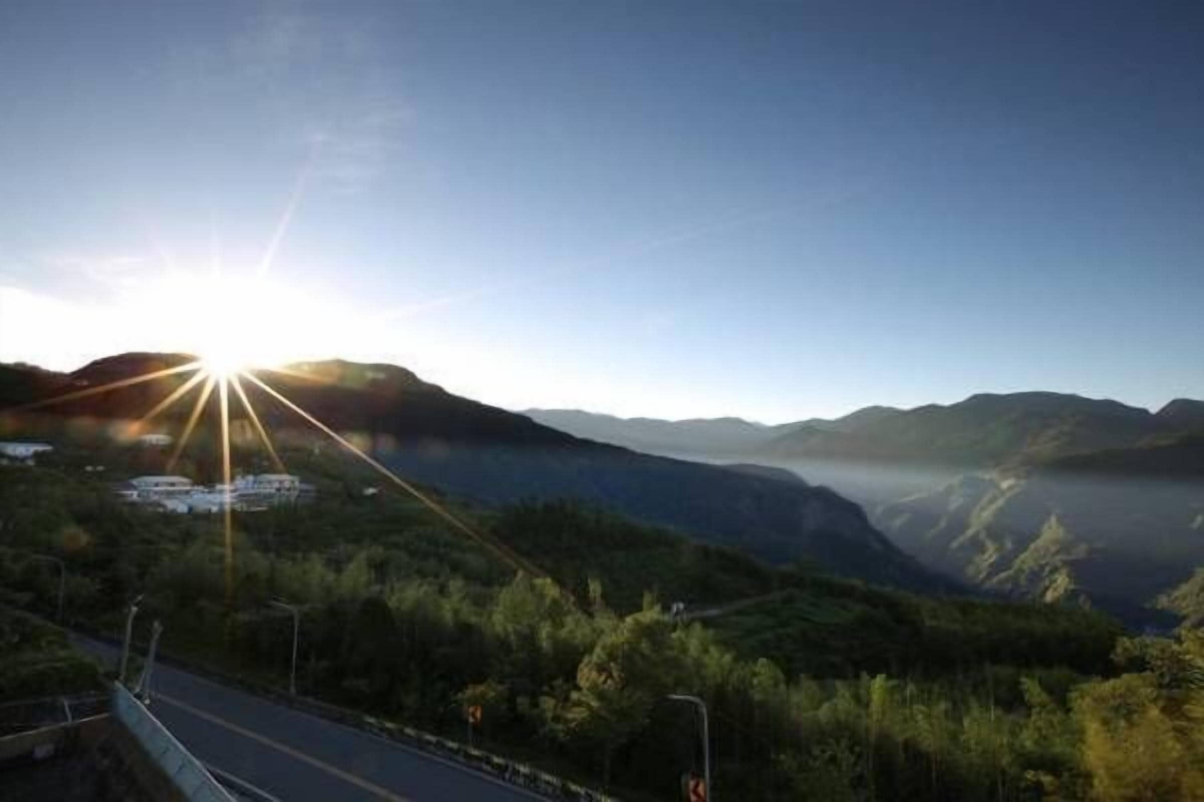 Une route avec un pont et des montagnes en arrière-plan.