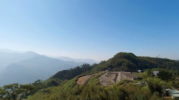 A hilly landscape with a large open area that appears to be a construction site or cleared land.
