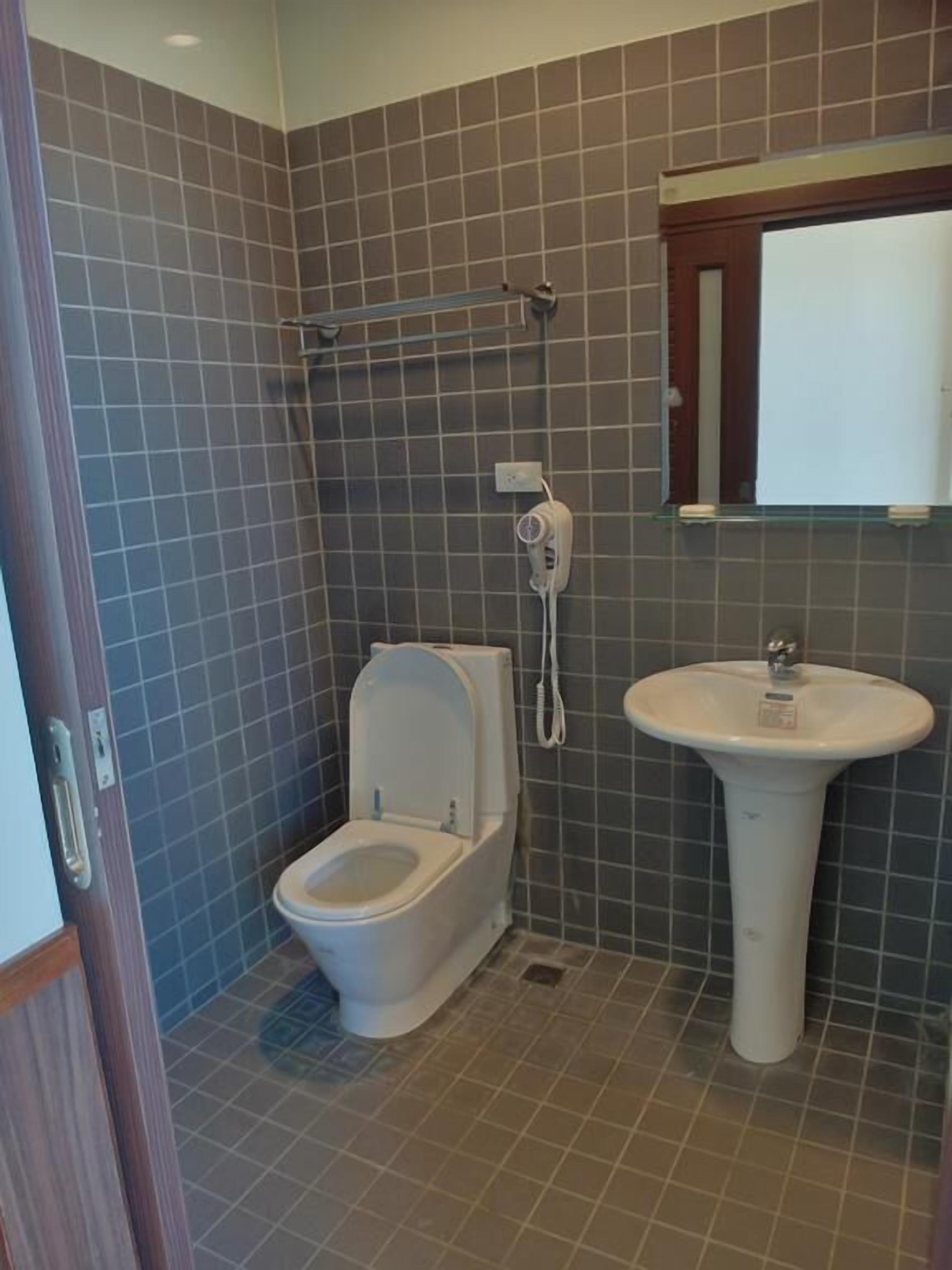 A bathroom with a toilet, a sink, and a shower.