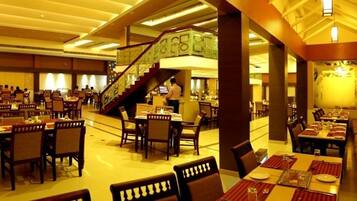 A spacious restaurant with multiple dining areas, a staircase, and a bar.