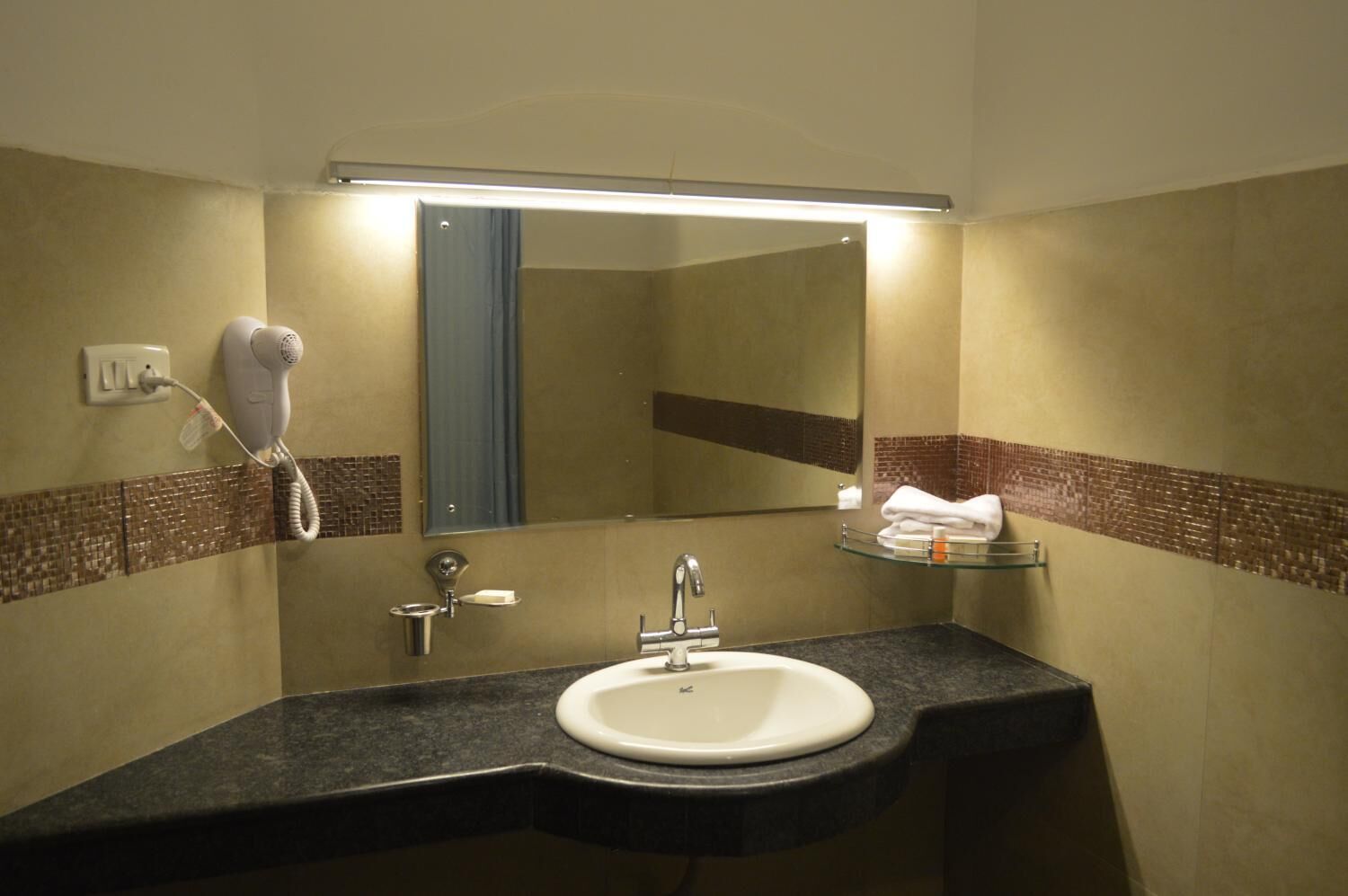 A bathroom with a sink, mirror, towel rack, and hairdryer.