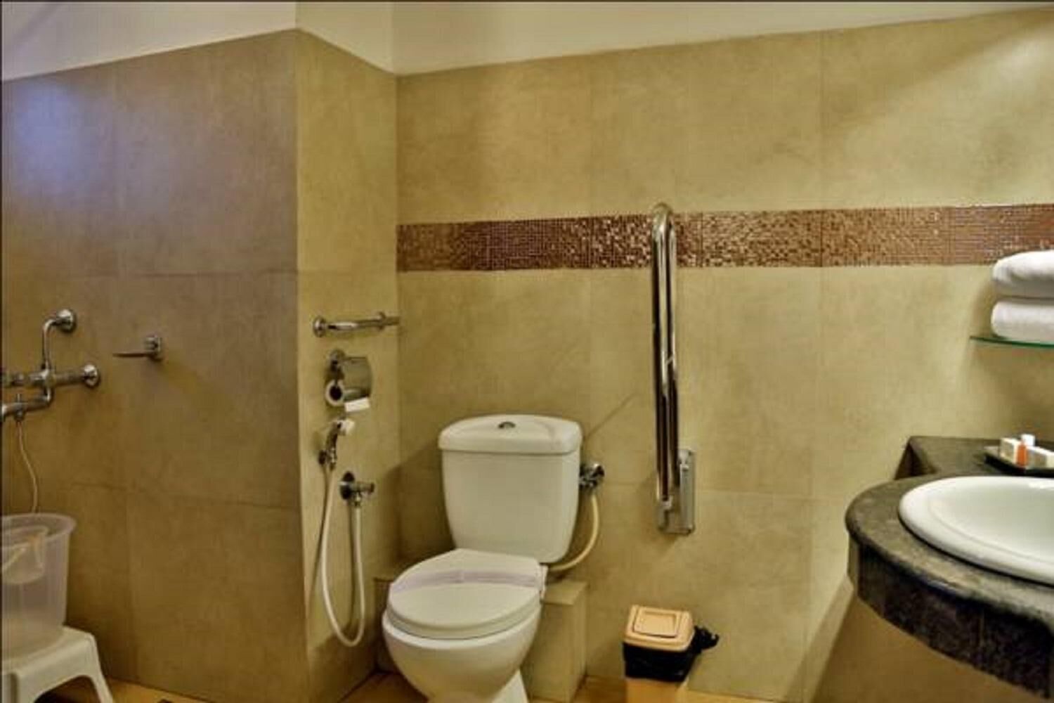 A bathroom with a toilet, a shower, and a sink.