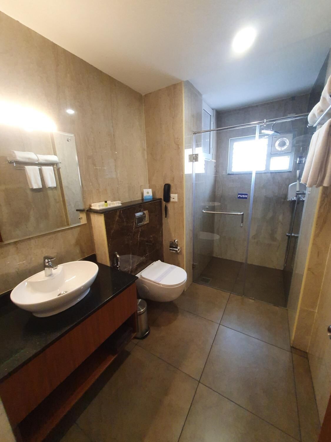 A modern bathroom with a double sink, a toilet, and a glass-enclosed shower.