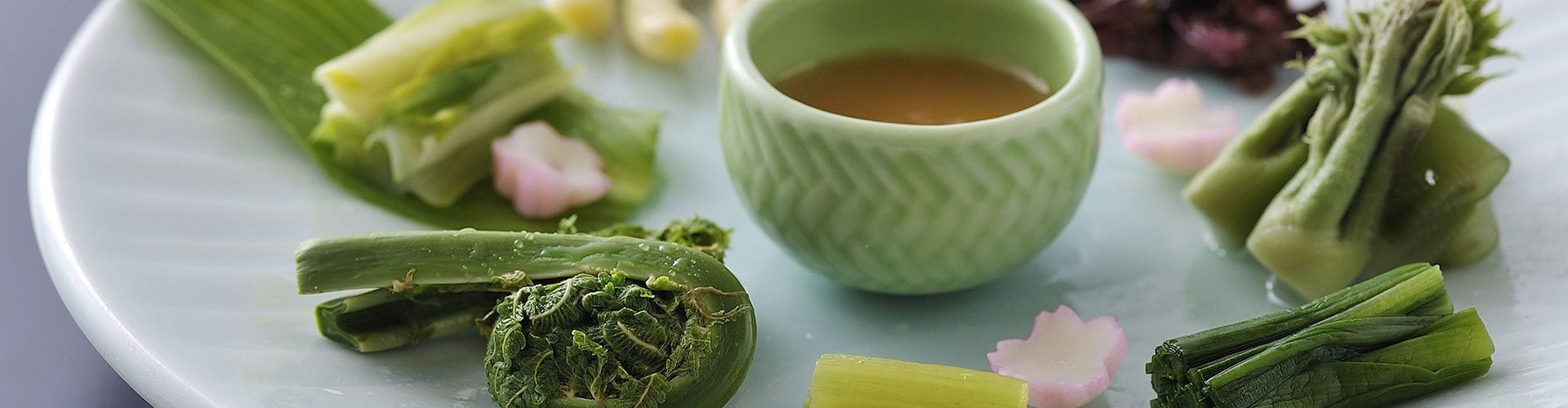 Une assiette contenant divers légumes et une tasse de thé.