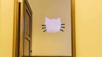 A room with a door labeled "201 Hello Kitty" and a cat-shaped decoration on the wall.