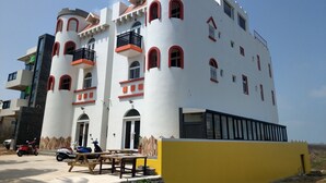Un immeuble à plusieurs étages, doté d’une façade blanche, de touches de couleur rouge et de balcons.