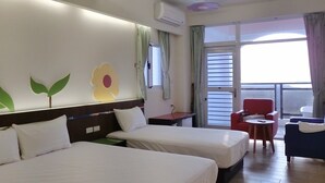 Une chambre d’hôtel avec deux lits, une petite table, une chaise rouge et un balcon avec vue.