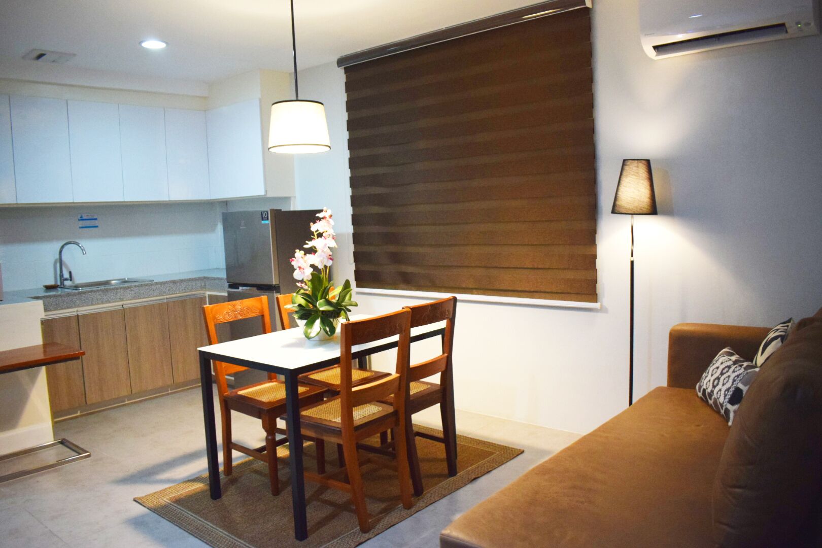 Un espacio habitable compacto con comedor, kitchenette y sofá.