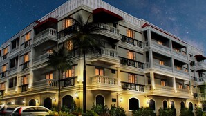 A multi-story hotel with balconies, arched windows, and a parking area. - Paradores de Vigan (Vigan)