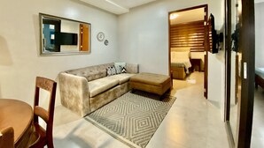 A living room with a sofa, a chair, a rug, and a mirror on the wall. - Paradores de Vigan (Vigan)