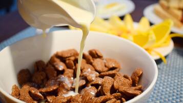 A bowl of cereal with milk being poured into it.