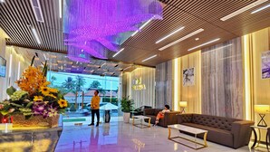 A modern lobby with a wooden ceiling, a large digital display, a sofa, and a coffee table. - Melissa Hotel (Nha Trang)