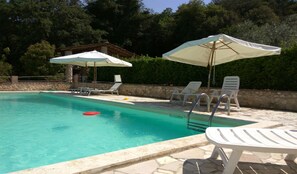 Una piscina al aire libre, tumbonas