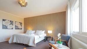 Ein Hotelzimmer mit Bett, Schreibtisch, Stuhl und Fenster.