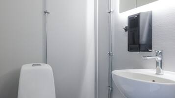 A modern bathroom with a white toilet, a sink, and a mirror.