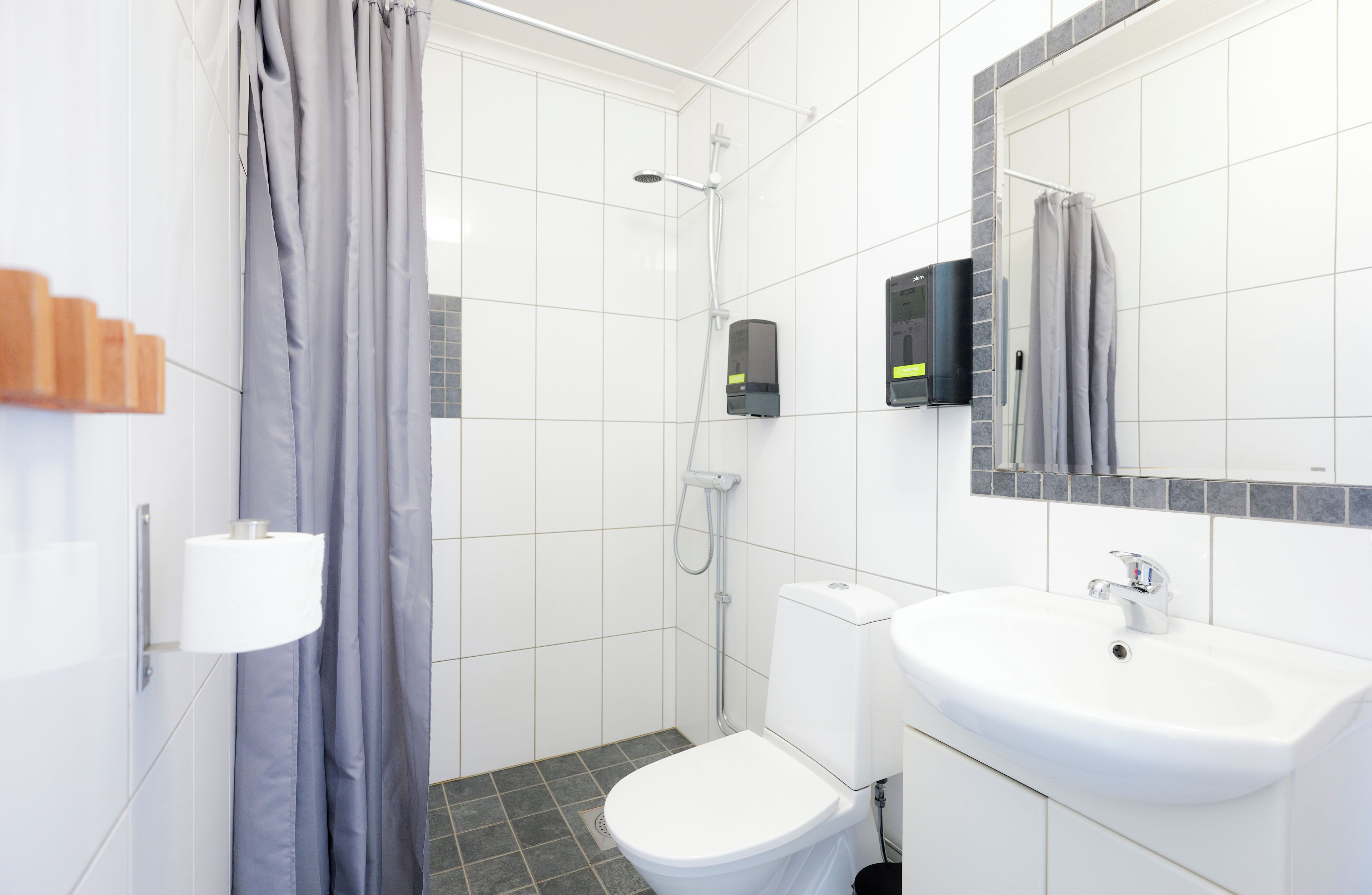 A modern bathroom with a toilet, sink, and shower.