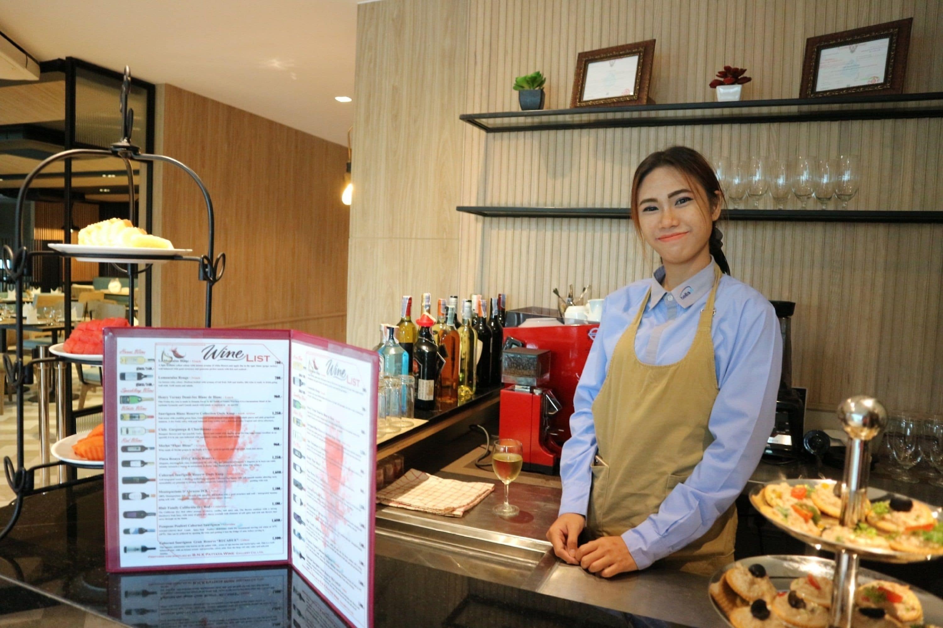 Zona de bar con carta de vinos, varias botellas y una bandeja con alimentos.