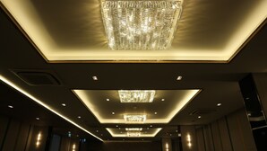Un pasillo de hotel con múltiples candelabros e iluminación empotrada.