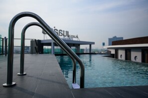 Piscina com grades de metal e um edifício ao fundo.