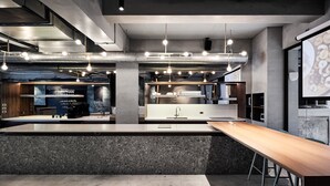 A modern kitchen with granite countertops, stainless steel appliances, and pendant lighting. - Waterfront Hotel (Taipei)