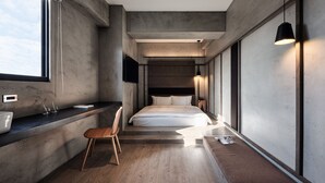 A modern bedroom with a large bed, a bedside table, a chair, and a window. - Waterfront Hotel (Taipei)