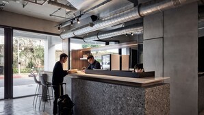 A modern bar area with a counter, stools, and a refrigerator. - Waterfront Hotel (Taipei)