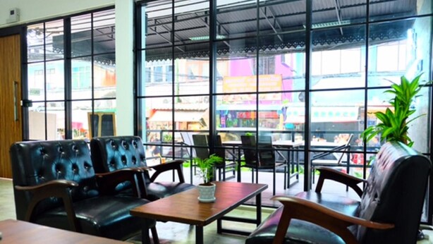 Un restaurante con asientos de cuero, una mesa de madera y ventanas amplias que dan a la calle.