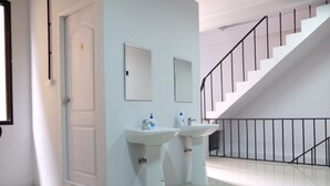 Un baño moderno con dos lavamanos, un espejo y una escalera.
