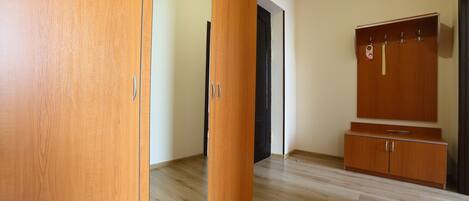 Una habitación con un armario de madera, un aparador de madera y una puerta.